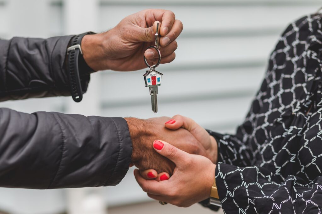 Realtor giving the key to a happy home buyer - Why Real Estate Agent is a Good Career